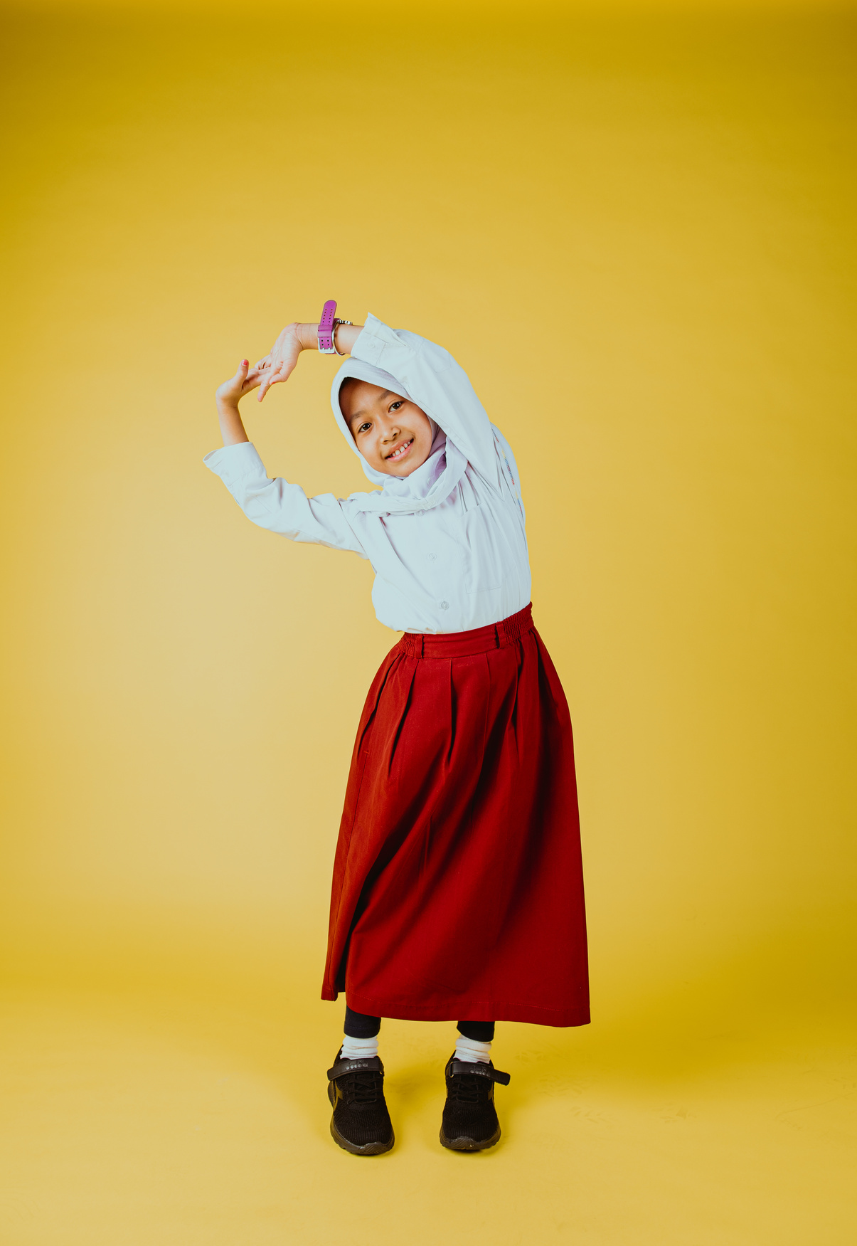 Schoolgirl in Hijab on Yellow Background